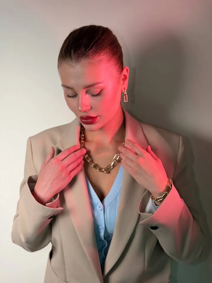 Gold chain necklace and bracelet styled with a blazer